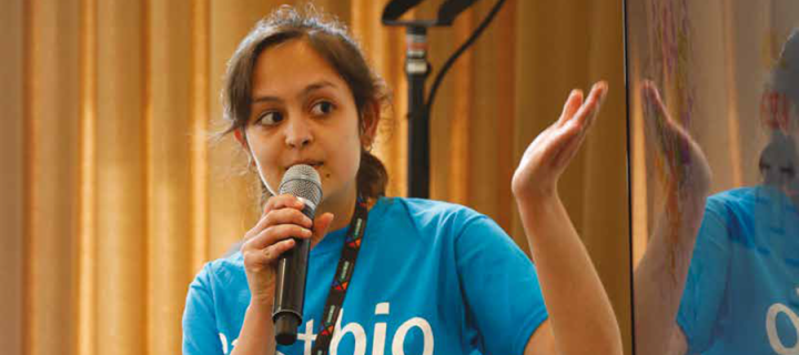 A student wearing an eastbio tshirt talks into a microphone