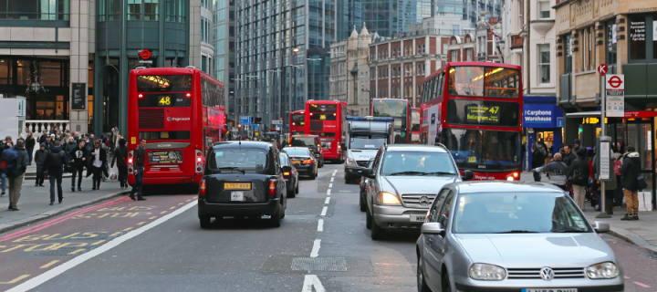 A busy street in London with buses, taxis, vans and cars