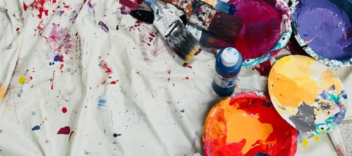 Multicoloured paint splashed over a white cloth