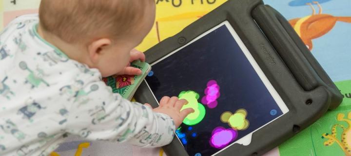 A baby interacts with a digital game on an ipad
