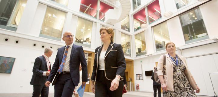 Professor Charlie Jeffery and First Minister Nicola Sturgeon walk through a building. 