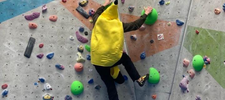 Photo of a person in a banana suit on a climbing wall