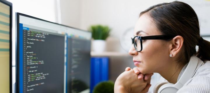 Woman looking at code list on computer screen