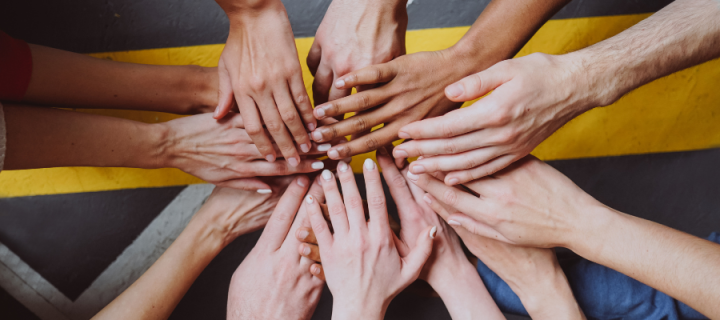Multiple people's hands reaching together