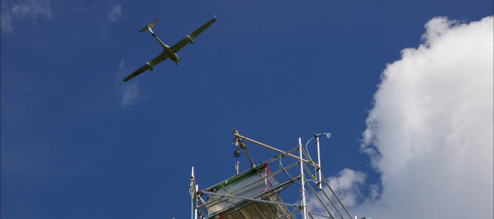 An aircraft  flying over a research tower 