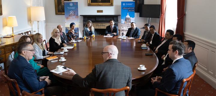 James Smith hosts a meeting around a wooden table in Old College