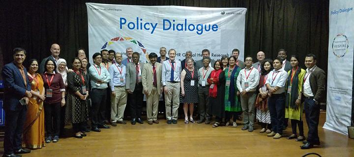 Group photograph inside in front of 'Policy Dialogue' banner