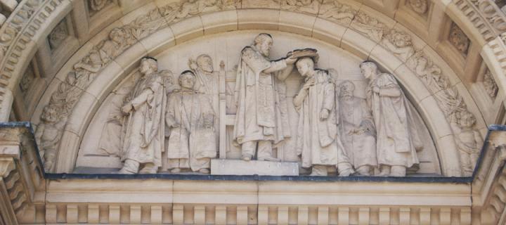 Carving of scholars in stonework of McEwan Hall exterior