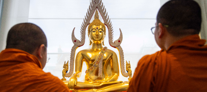 Colour photo of two monks from Edinburgh's Dhammapadipa Temple welcoming a Buddha statue to the National Museum of Scotland.