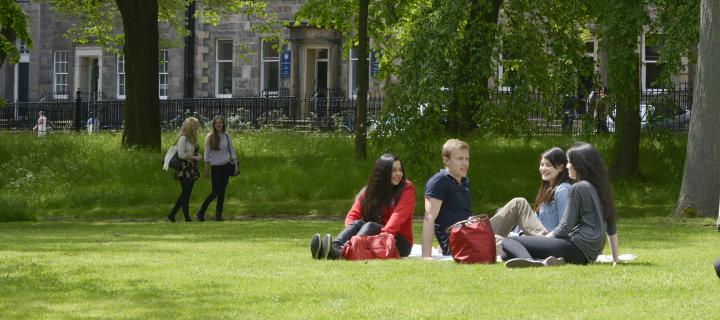 Students sitting on the grass in George Square Gardens.