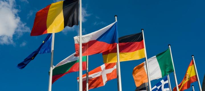 Flags of different European countries against a blue sky