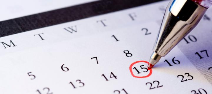 Pen drawing a red circle on a calendar