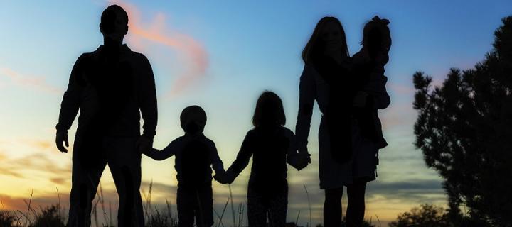 Family siloutted by sunset