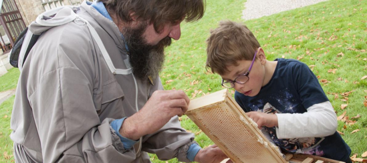 Scientist Dr Mark Barnett showing a young child the bee apiary