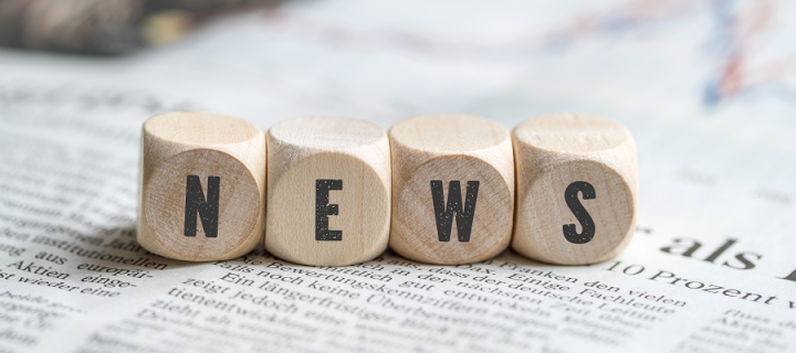 Individual wooden blocks spelling news on top of a newspaper
