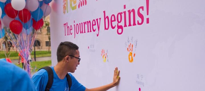 A student puts his handprint on a welcome wall at Zhejiang