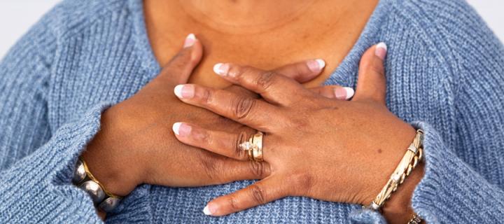 A woman places her hands on her chest