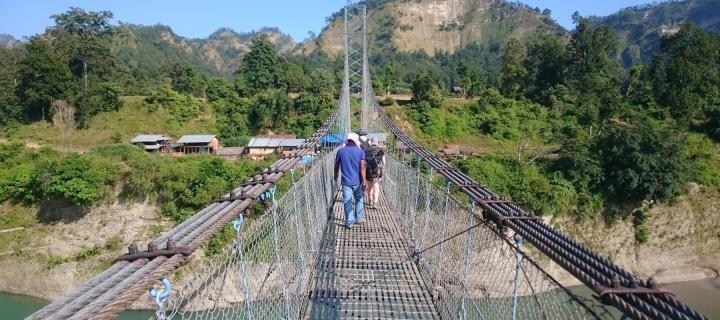 Walking across a bridge doing field work in the Himalayas