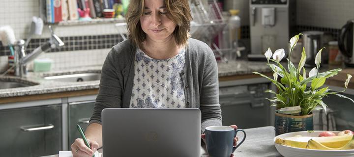 Woman studying on laptop in kitchen