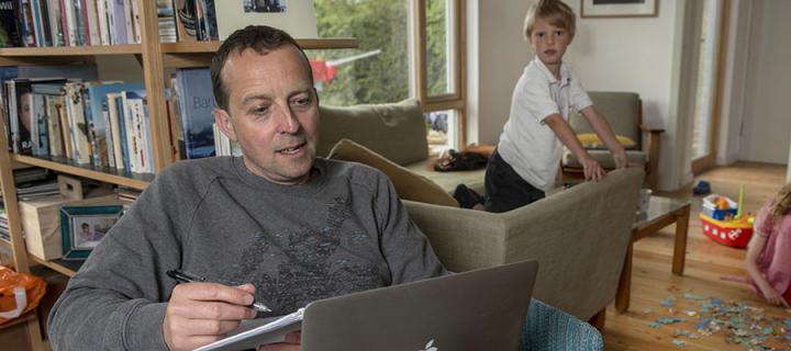 Man studying at home with kids