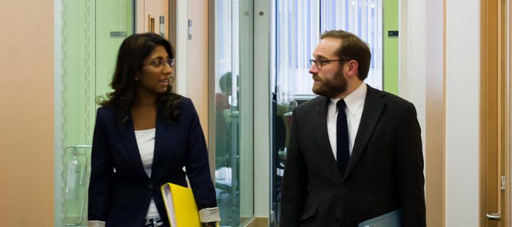 Two members of staff talking in a corridor