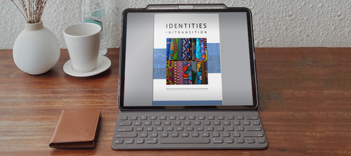 Laptop on desk showing Identities in Transition Photovoice book