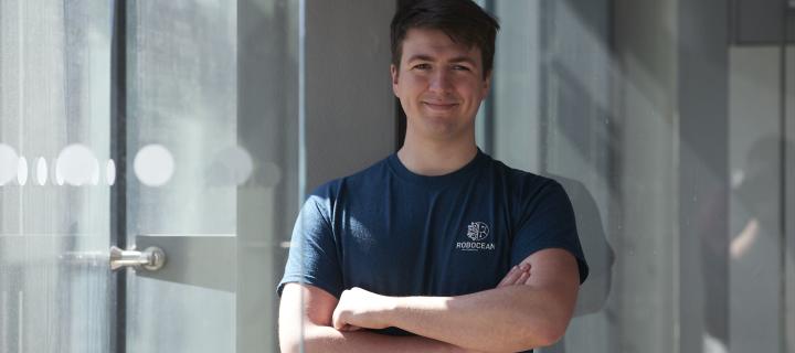 Niall McGrath, Engineering graduate and founder of Robocean stands with crossed arms smiling to camera