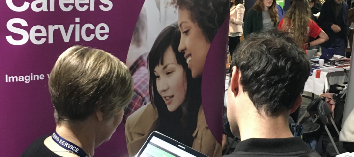 People talking in front of Careers Service banner