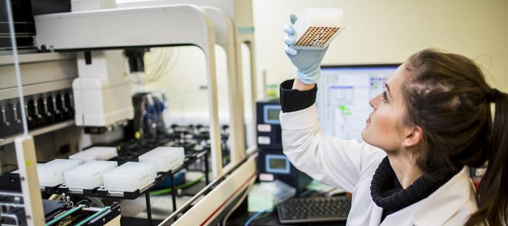 Researcher examining equipment in lab