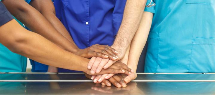 Group of people placing hands on top of each other