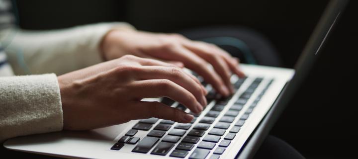 Close-up of fingers typing on a laptop