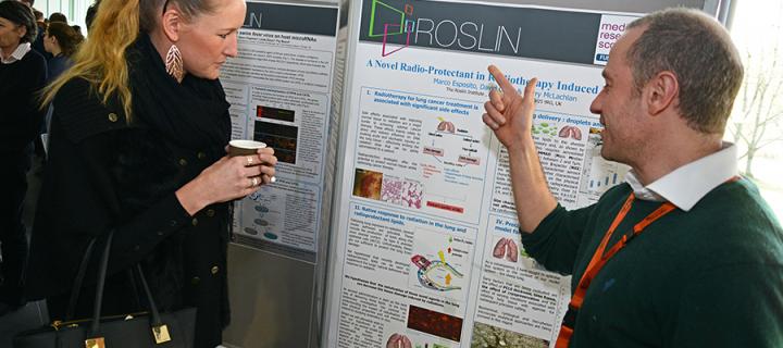 Student at a poster board explaining research