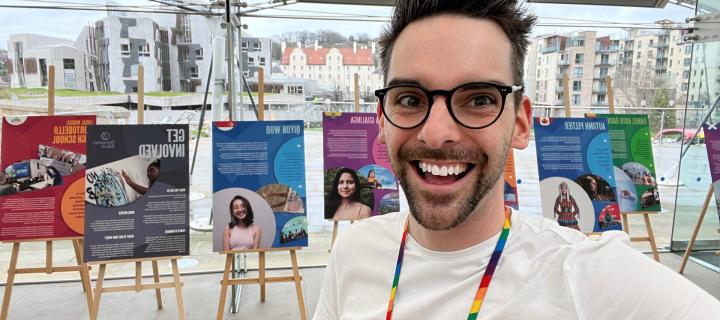 Man wearing white shirt and glasses smiling at camera
