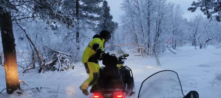 Photograph of David mounting a snow mobile at his work site in Arctic Sweden