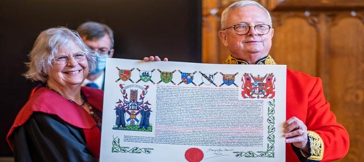Colour Image of the Lord Lyon presenting Professor Susan Hardman Moore with the New College coat of Arms