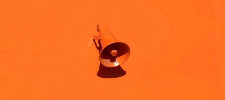 Orange megaphone on an orange wall