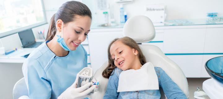 girl in dentish chair with female dentist