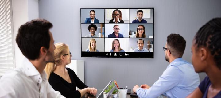 People in an office on a video conference with other team members