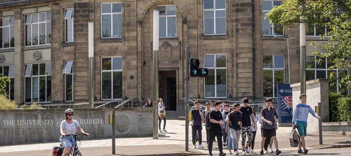 Cyclist and people crossing the road outside the King's Buildings campus 