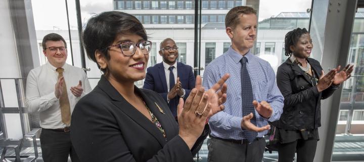 Corporate employees clapping in an office