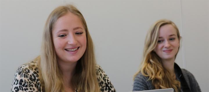 2  female students share laptop