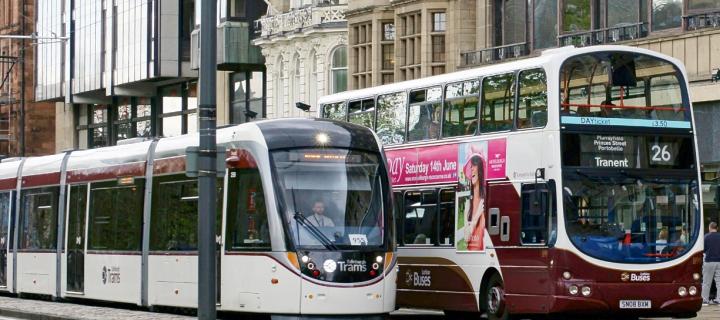 A photo of a tram and  abus on princes street, edinburgh