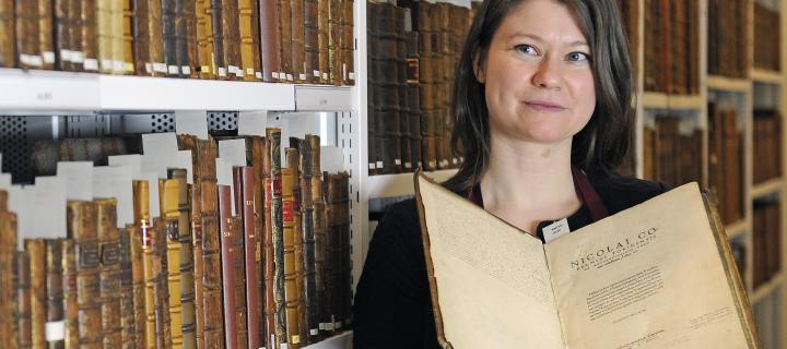 researcher with book from Adam Smith's library