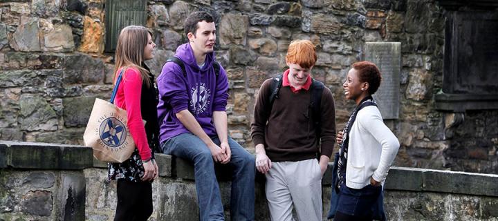 Photo of students chatting in Greyfriars Kirkyard in Edinburgh's Old Town with the Castle in the background.