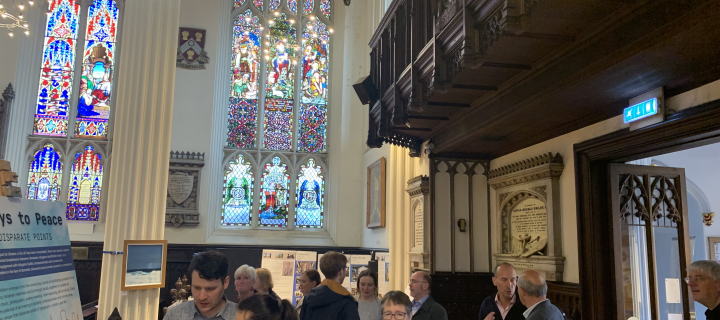 Coloured photo of an interior of a church with a crowd of people