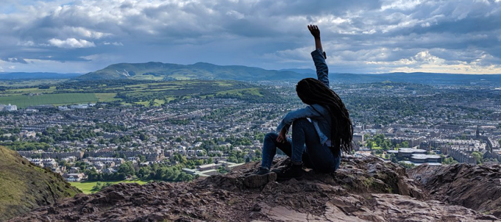 Joyous scholar on hilltop looking out over Edinburgh