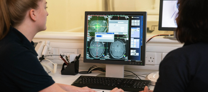 Two researchers studying brain scans on the computer