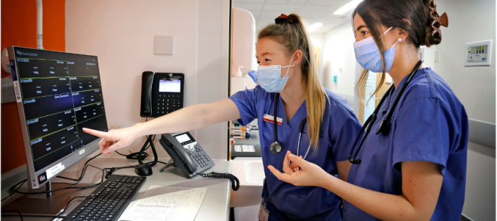 Medical students pointing at screen.