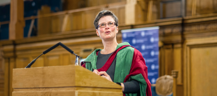 Colour photo of Professor Hannah Holtschneider delivering her Inaugural Lecture at the lectern in the Assembly Hall