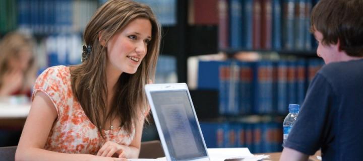 Two students on their computer in the library 